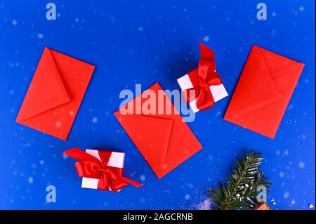 Mockup on a blue background with red envelopes and white christmas gift boxes. Banner. Long format. Copy space Stock Photo