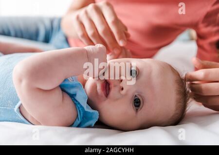 selective focus of surprised infant baby near mother Stock Photo