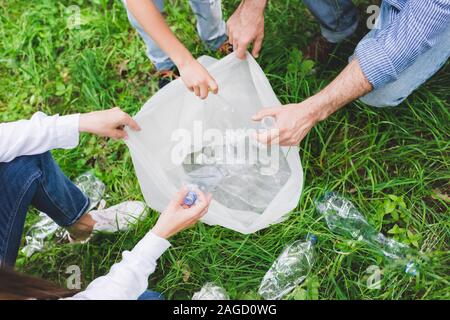 top view of family putting garbage in plastic bag in park Stock Photo