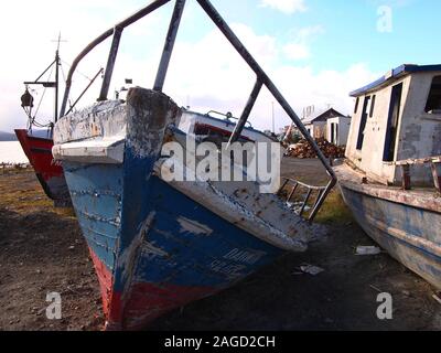 Scrapped old artisanal fishing vessels in a ship graveyard near Puerto Williams (Chile), the world' southernmost village Stock Photo