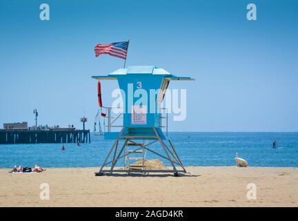 People sunbathing on beach near Sterns Wharf at the Aqua blue lifeguard stand #3 in Santa Barbara, CA, USA Stock Photo