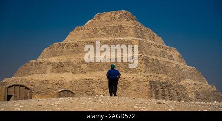 NOVEMBER 12, 2019, CAIRO, EGYPT - Sakkara Pyramid known as 'Step Pyramid' first pyramid of Egypt shows man admiring structure Stock Photo