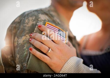 View of a mid adult woman's hand resting on a mid adult man's arm. Stock Photo