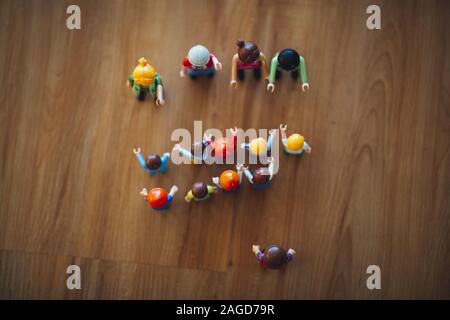High shot of colorful plastic miniature toys on a wooden table under a white light Stock Photo