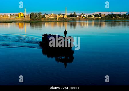 NOVEMBER 17, 2019 - LUXOR EGYPT - Silhouette of man on boat at unrise on the Nile River, Luxor, Egypt Stock Photo