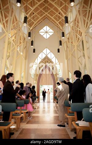 father walking bride down the aisle in dramatic arched church Stock Photo