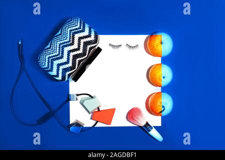 Female fashion layout with white paper sheet, orange tangerines and female accessories on classic blue color background. Christmas, Valentine's day Party concept. Copy space. Classic Blue color 2020. Stock Photo