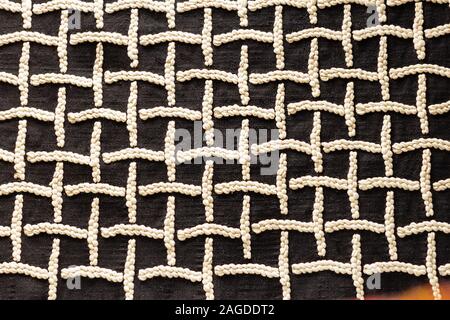 white embroidered designs on black cloth square Stock Photo