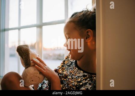 young girl playing at home with her toys in Sweden at sunset