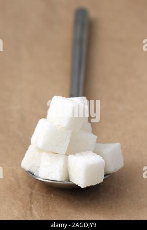 White sugar cubes pile in metal silver spoon Stock Photo