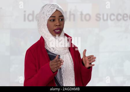 Young female african american businesswoman at business conference room with public giving presentations. Audience at the conference hall. Entrepreneu Stock Photo