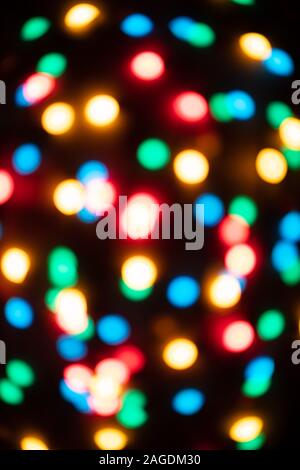 Multicolored abstract bokeh background. Colorful Christmas garland texture. Defocused luminous garland. Stock Photo