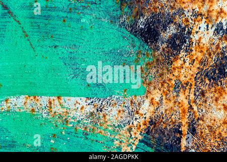Fragment of rusty metal black door. The surface is partially painted with green and white paint with a clear stroke. Abstract colorful texture backgro Stock Photo