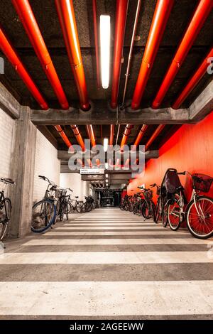 Vertical shot of bicycles parked inside the garage with red walls Stock Photo