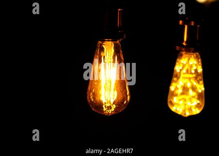 Classic retro incandescent led electric lamp warm white on black background, Vintage light bulb Stock Photo