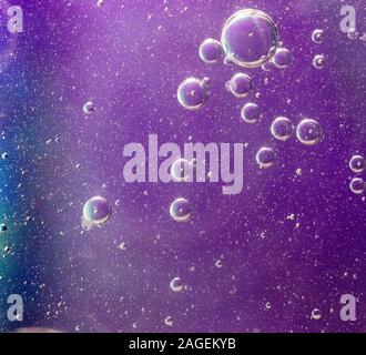 Beautiful shot of soap bubbles on a purple background with interesting textures Stock Photo