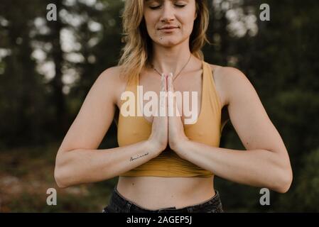 Woman practising yoga in forest Stock Photo