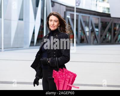 Woman in black suit walking in city Stock Photo