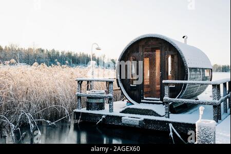 wooden sauna on a jetty covered in snow on a lake in Sweden in winter Stock Photo
