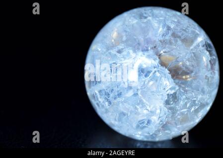 Glowing crystal ball with cracks inside on a dark background. The process of predicting the future Stock Photo