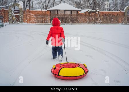 Child having fun on snow tube. Boy is riding a tubing. Winter fun for children Stock Photo