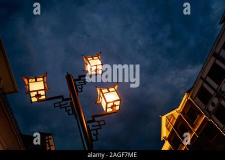 Brightly lit lamppost on the street in Wulingyuan after dusk at night, Hunan Province, China Stock Photo