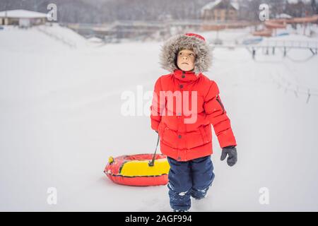 Child having fun on snow tube. Boy is riding a tubing. Winter fun for children Stock Photo