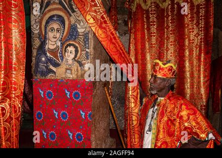 Ethiopia, Amhara Region, Lalibela, Arbatu Ensessa, Biblia Chirkos, priest in robes showing nativity wall painting Stock Photo