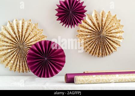 Simple DIY paper stars/snowflakes hanging on a wall. Party decorations Stock Photo