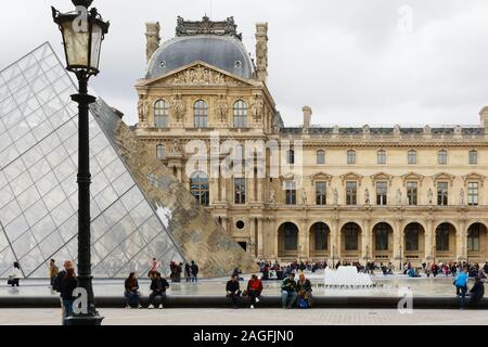 PARIS, FRANCE - 04 OCTOBER, 2019: People visiting Louvre Museum with Louvre Pyramid Stock Photo