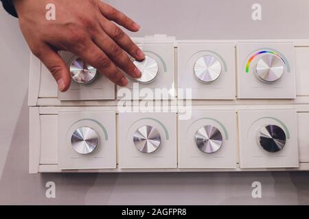 moderm switch control in hotel room Finger pressing light switch Stock Photo