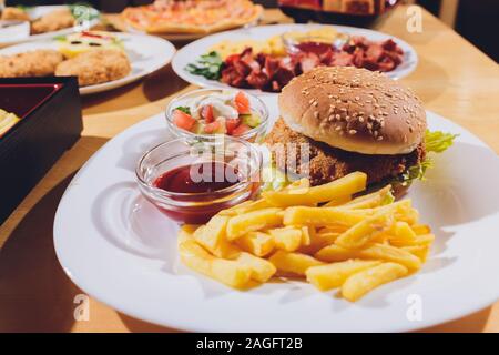 Mini Burger platter with fries Salad on the table Stock Photo