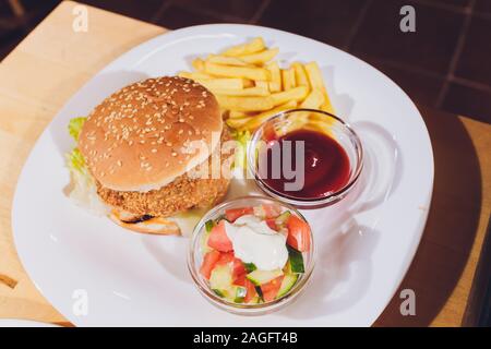 Mini Burger platter with fries Salad on the table Stock Photo