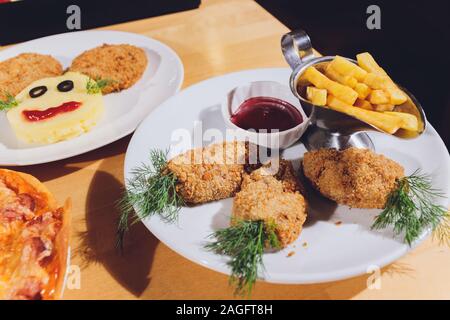Child food. Funny food. Plate with cutlets and mashed potatoes in the form of a monkey faces. Children's menu Stock Photo