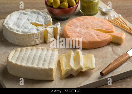 Diversity of traditional French cheese like Camembert, Munster and Le coq de Bruyere on a cutting board Stock Photo