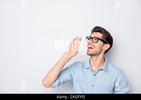 Photo of cheerful positive guy shouting at empty space wearing spectacles advertising isolated over grey color background Stock Photo