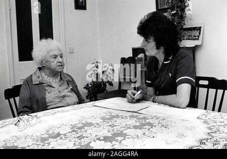 District nurse visiting elderly woman at home, Nottingham UK 1990 Stock Photo