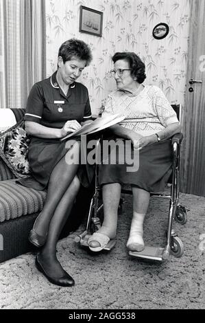 District nurse visiting elderly woman at home, Nottingham UK 1991 Stock Photo