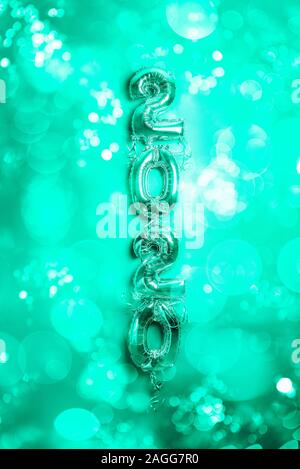 Balloon Bunting for celebration of New Year 2020 made from Silver Number Balloons. Holiday Party Decoration or postcard concept with top view and copy space. Toned in blue green Stock Photo