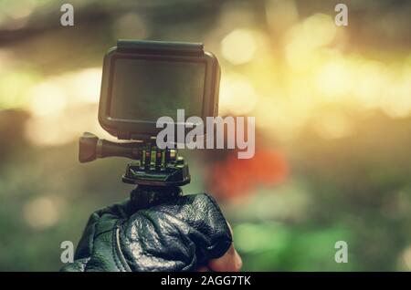 Action camera in hand in leather glove. Stock Photo