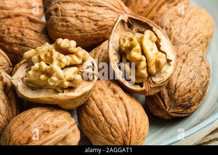 Walnuts in a light blue plate on a rustic wooden table Stock Photo