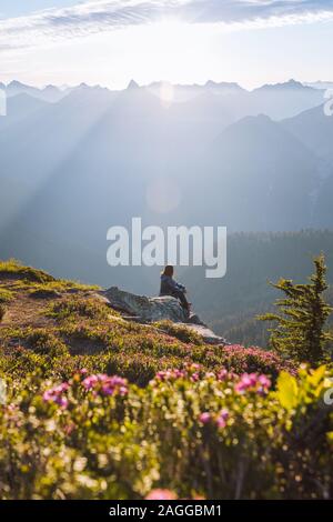 Female hiker enjoying sun on peak, Winchester Mountain, North Cascades, Washington Stock Photo