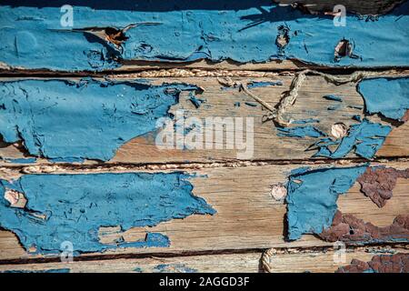 Old, peeling blue paint and rope calking between planks of an old rotting hulk in the bay behind Luderitz Stock Photo