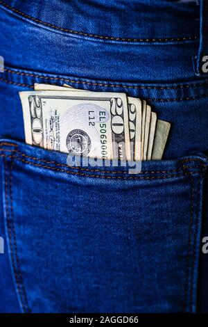 Banknotes close up, money in a jeans pocket. Dollars stick out of the jeans pocket, finance and currency concept. Concept of saving or spending money Stock Photo