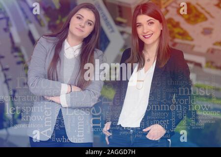 Two Young successful female entrepreneurs standing in hall  and looking for the camera, two businesswomen posing for promotional content while standin Stock Photo