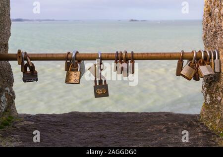 Love padlocks hanging on rail on city walls at St Malo, Saint Malo, Brittany, France in December - concept of romance love romantic Stock Photo