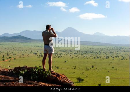 Ranger looking out from hilltop, Lualenyi Game Reserve, near Tsavo East National Park, Kenya Stock Photo