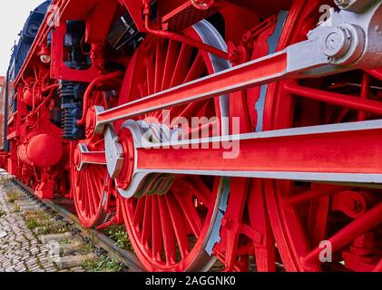 Red iron wheels and connecting rods of a historic locomotive Stock Photo