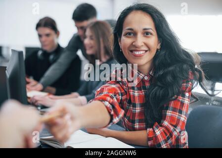 Taking item. Group of young people in casual clothes working in the modern office Stock Photo