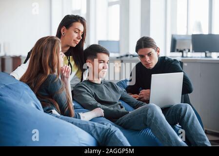 Hard to find information that we need. Group of young people in casual clothes working in the modern office Stock Photo